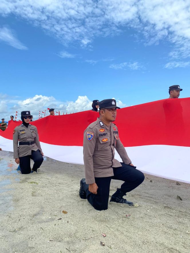 
 Pembentangan Merah Putih Di Teluk Bone, Kapolsek Pelabuhan Bersama Personilnya Lakukan Pengamananan Dan Pembentangan