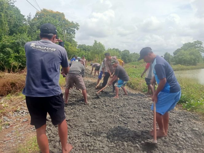 
 Bhabinkamtibmas Bersama Warga Gotong Royong Perbaiki Jalan Rusak di Desa Binaannya