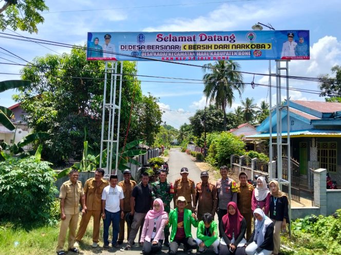 
 Dukung Program Desa Bersinar, Bhabinkamtibmas Hadiri Pemasangan Baliho Bersih Narkoba