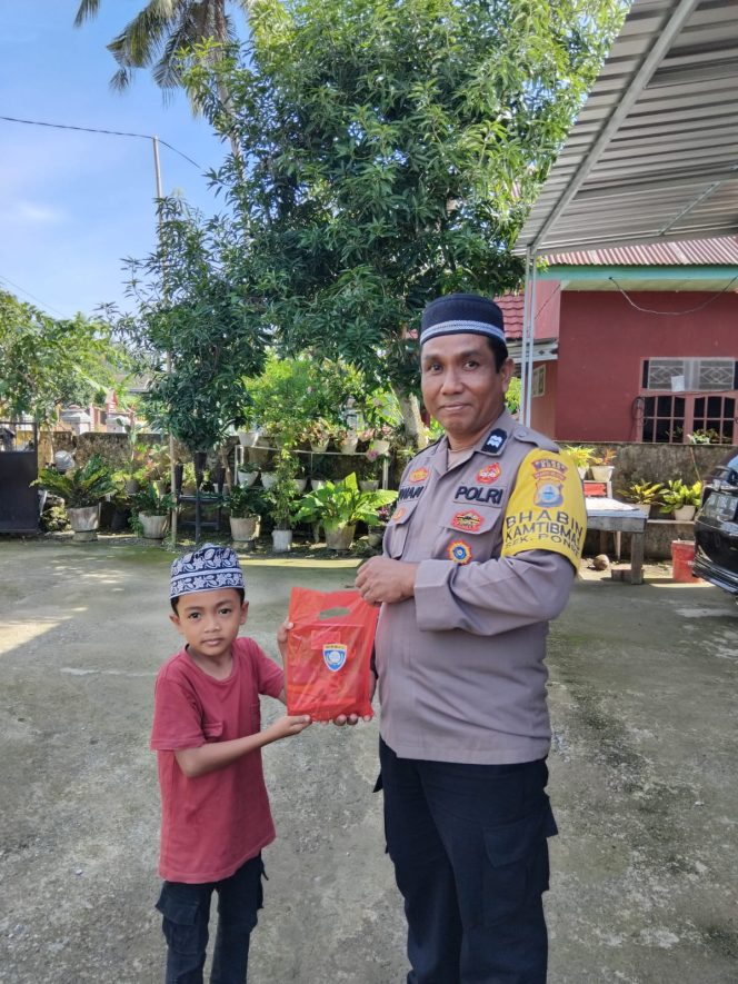 
 Bhabinkamtibmas Polsek Ponre berbagi alat tulis kepada anak anak saat sambang desa