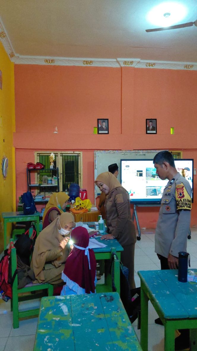 
 Peduli Kesehatan Anak Sekolah, Bhabinkamtibmas Hadir di Tengah Pelayanan Kesehatan Gratis